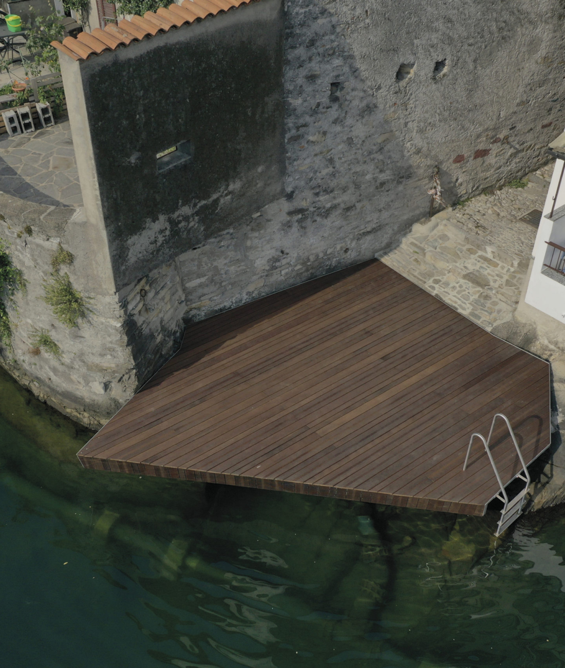 Piattaforma in acciaio e legno realizzata da Pifferi & Alpi sul Lago di Como, struttura su misura integrata nella roccia per accesso diretto all’acqua.