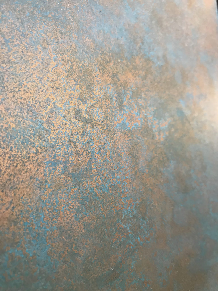 Superficie in rame trattata con processo di ossidazione controllata, che genera tonalità sfumate e variazioni cromatiche naturali. Una finitura dal forte impatto materico, ideale per progetti di design che richiedono calore, autenticità e un’estetica ricca di personalità.