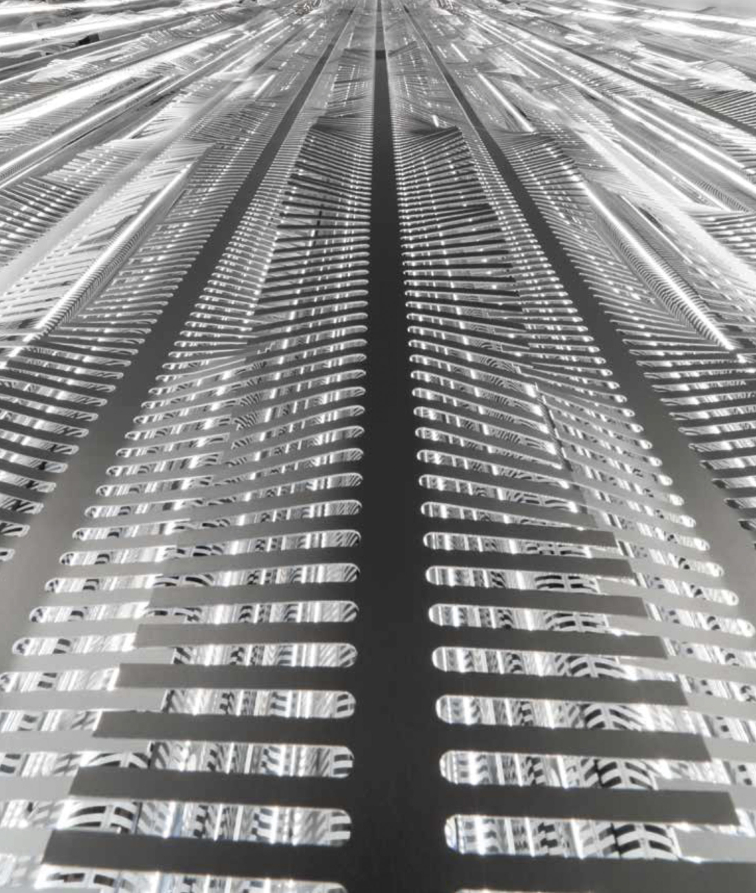 Rivestimento architettonico in acciaio inox realizzato da Pifferi & Alpi su disegno di designer, con texture geometrica lucida e tagli laser di precisione.