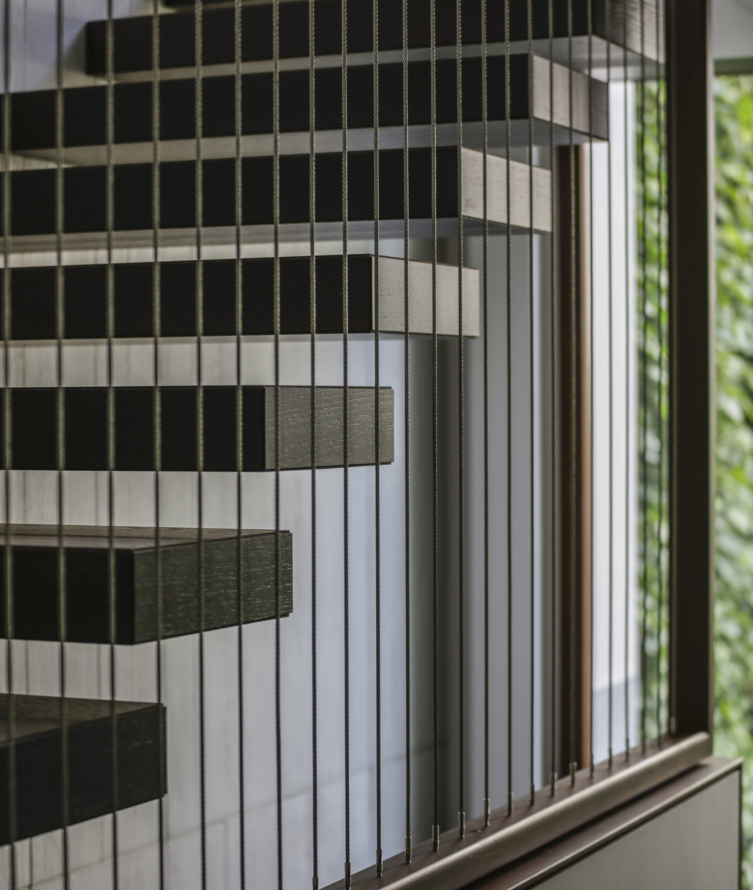 Scala moderna sospesa con tiranti in acciaio realizzata da per una residenza privata a Milano, design minimale e materiali di pregio.